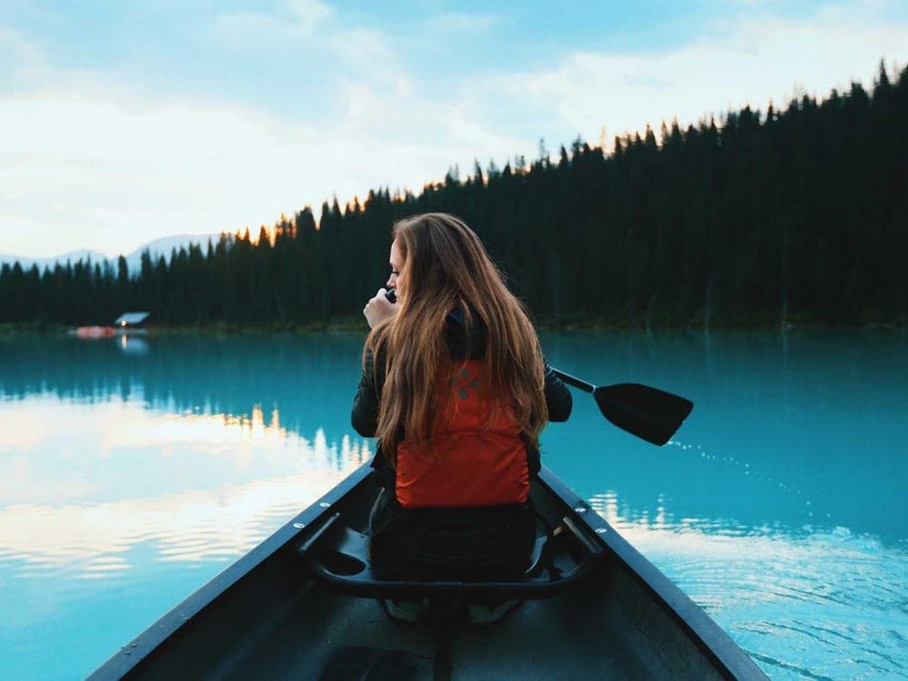 Woman paddling a canoe on a lake